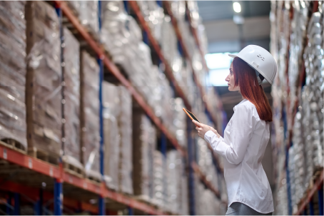 a woman watching tablet and the background is warehouse as a introduce for wms and sap
