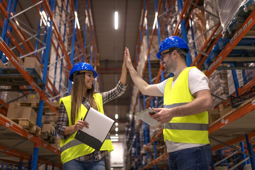Warehouse workers clapping hands together.Show the good cooperation between multiple warehouse