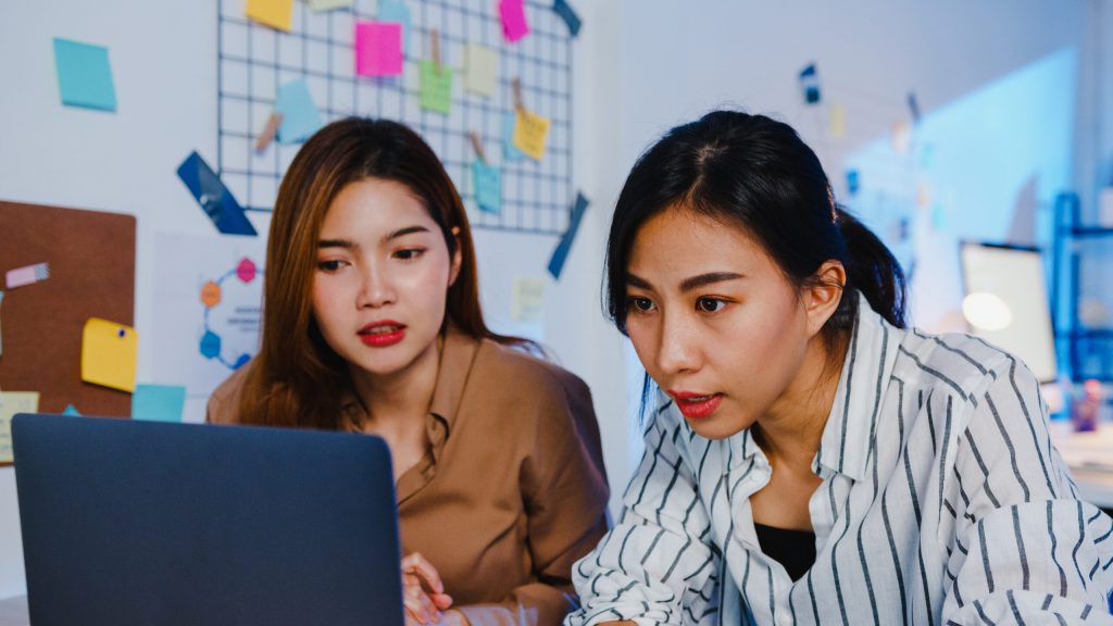 Group of Asia businesspeople using computer laptop presentation and communication meeting brainstorming ideas about new project colleagues working plan success strategy in night modern home office.