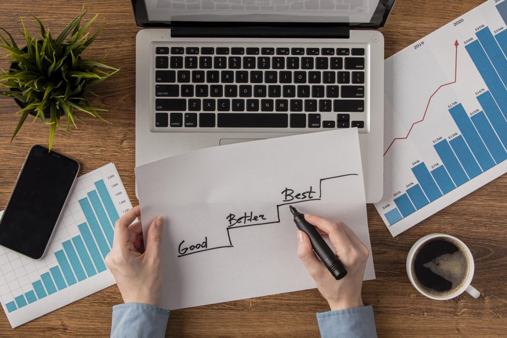 top-view-office-desk-with-growth-chart-held-by-hands-scaled