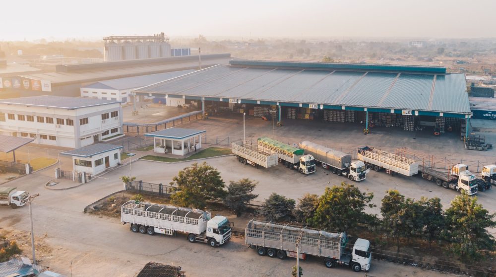 An aerial shot of factory trucks parked near the warehouse at daytime